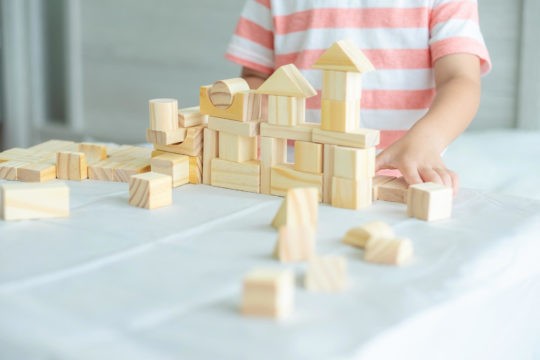 Close up of young boy building a house with blocks