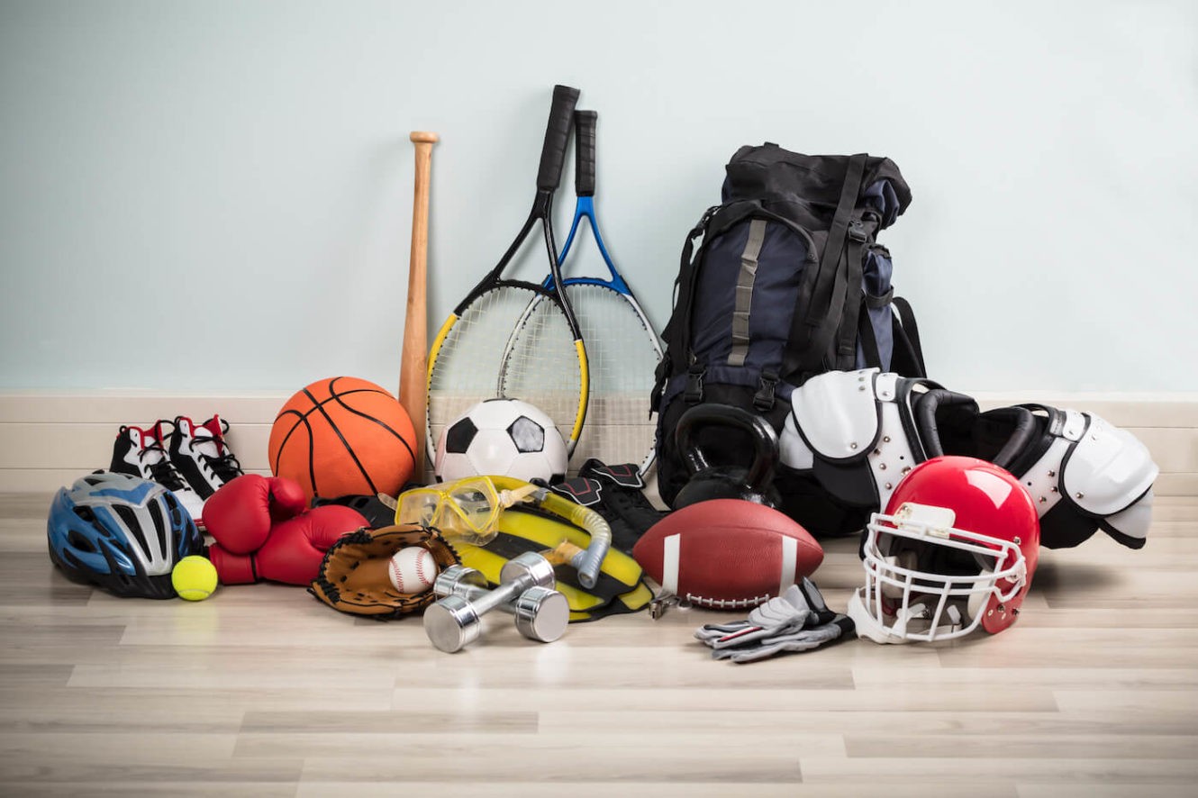 Various sports equipment on a hardwood floor