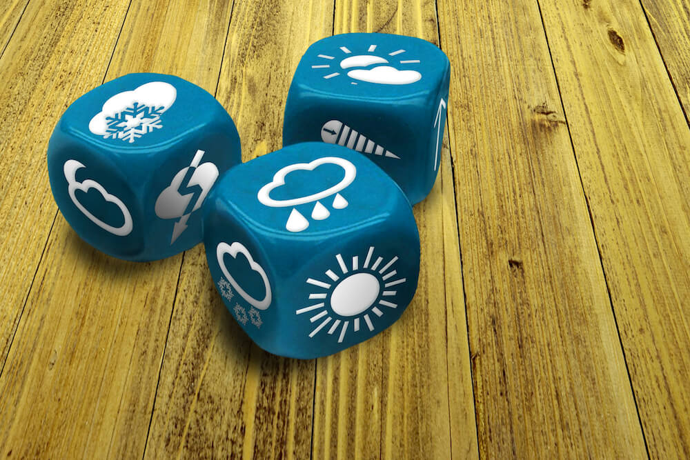 Close up of blue dice with different weather condition symbols on each side