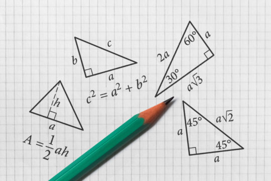 Several triangles drawn on graph paper surrounded by numbers and formulas
