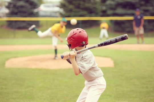 Young boy holding bat at baseball game