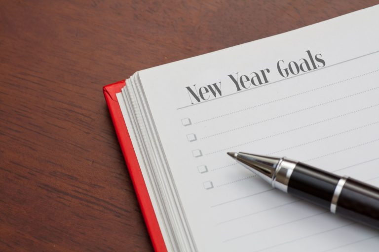 Pen and notebook with the heading 'New Year Goals'
