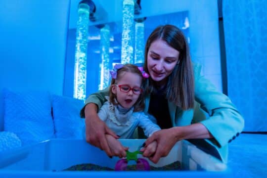 A teacher spends time with her student in a sensory room.